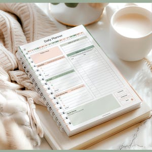 May include: A daily planner with a spiral binding, titled "Daily Planner". It includes sections for priorities, daily schedule, and a "Brain Dump" area. The pages have a soft colour palette of pink, green, and white, with a clean, organised layout.