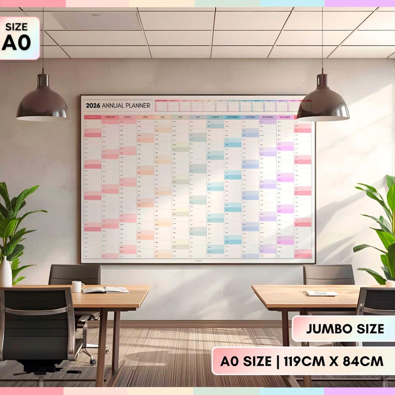 May include: A large 2026 annual planner in a modern office setting. The calendar is white with pastel-colored sections for each month. The size is AO, 119cm x 84cm. The text "2026 ANNUAL PLANNER" is at the top.
