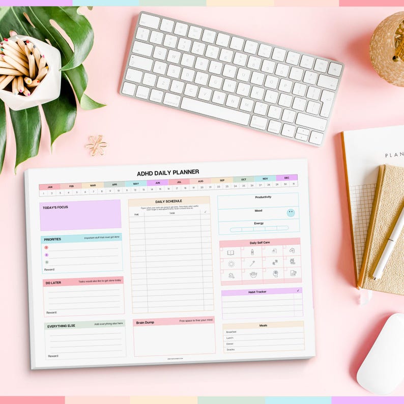 Pu&ograve; includere: Planner giornaliero per ADHD su una superficie rosa con una tastiera bianca, un mouse bianco e un taccuino. Il planner ha sezioni per l'orario giornaliero, le priorit&agrave; e la cura di s&eacute;. Il testo del planner include "Today's Focus" e "Brain Dump".