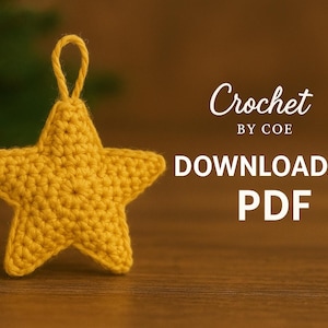 以下が含まれることがあります： 黄色いかぎ針編みの星のオーナメント。吊り下げ用のループが付いています。「Crochet by COE DOWNLOADABLE PDF」の文字が見えます。お祝いの装飾です。