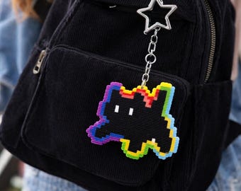 Chaveiro de gato em pixel art: pingente para bolsa com contorno de arco-íris feito com contas Perler.