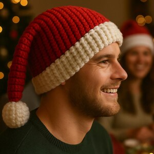 Könnte beinhalten: Ein rot-weißer gehäkelter Weihnachtsmannhut mit einem weißen Bommel. Der Hut wird von einer lächelnden Person getragen. Der Text auf dem Bild lautet "A touch of crochet for the holiday spirit" und "www.crochix.com".