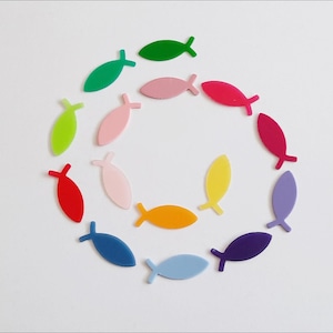 Könnte beinhalten: Eine Anordnung von bunten, fischförmigen Acryl-Anhängern in einem Kreis. Die Anhänger sind in verschiedenen Farbtönen wie Grün, Rosa, Rot, Gelb, Blau und Lila auf weißem Hintergrund angeordnet. Diese dekorativen Anhänger eignen sich für Bastelprojekte.