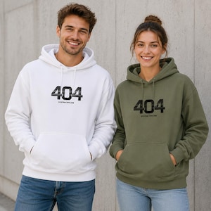 Könnte beinhalten: Ein weißer Kapuzenpullover und ein olivgrüner Kapuzenpullover, beide mit einem schwarzen Grafikdruck auf der Brust, der den Text 404 und darunter die Worte SYSTEM OFFLINE zeigt. Jedes Kleidungsstück hat eine Kapuze mit Kordelzug und eine Kängurutasche.
