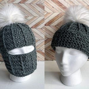 Könnte beinhalten: Eine dunkelgrüne Häkelmütze mit einem weißen Bommel und einer Gesichtsmaske. Die Mütze hat ein strukturiertes Strickmuster.