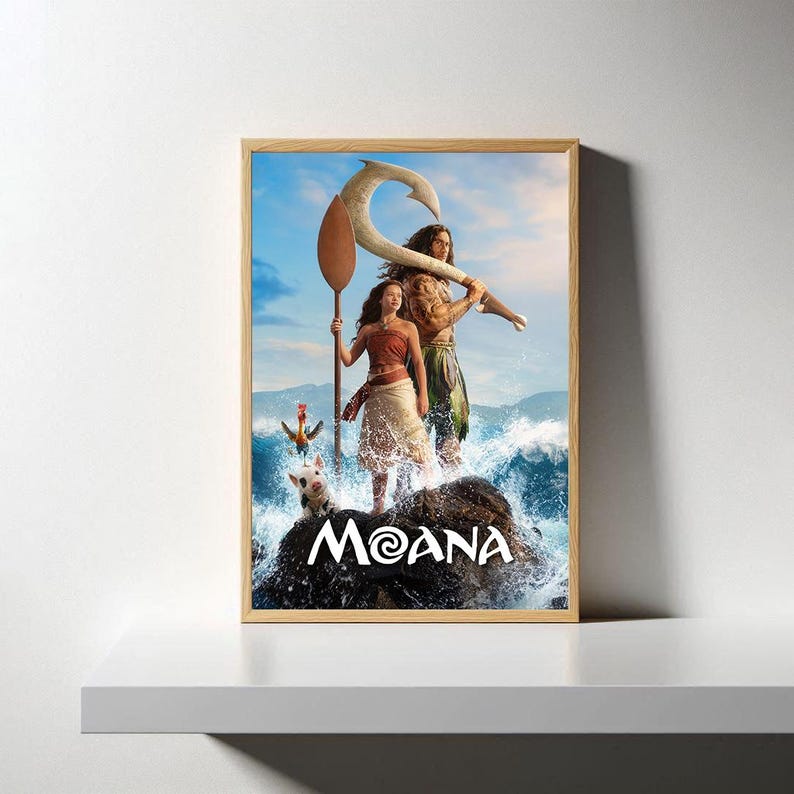 May include: Framed poster featuring characters from the animated film Moana. The artwork depicts two main characters standing on a rock in front of ocean waves. The title "Moana" is displayed in white text at the bottom.