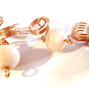 May include: Three copper wire hair coils with white and brown gemstone beads.
