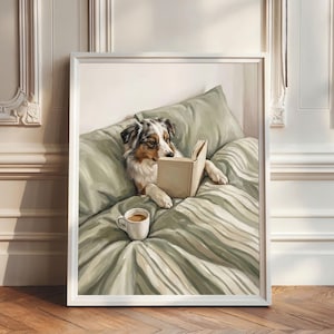 Könnte beinhalten: Gerahmter Kunstdruck eines Hundes, der im Bett ein Buch liest. Der Hund hat schwarzes, weißes und braunes Fell. Eine Tasse Kaffee steht neben dem Hund. Das Bett hat ein grün-weißes Streifenmuster. Der Rahmen ist weiß.