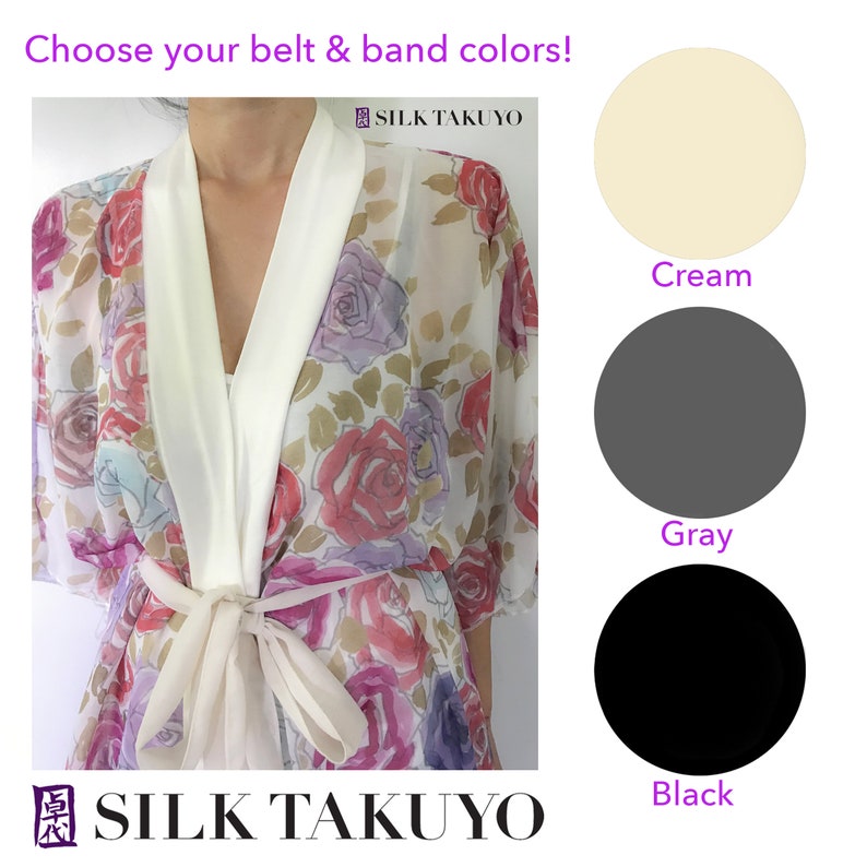 May include: A white silk robe with a floral print and a white sash. The robe has a V-neck and is made of sheer fabric. The sash is tied at the waist. The image shows four color options for the sash: cream, gray, black, and white. The text "SILK TAKUYO" is visible in the image.
