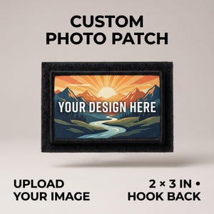 Puede incluir: Un parche fotográfico personalizado rectangular de 5,08 por 7,62 cm con reverso de gancho. El parche presenta una ilustración de paisaje con montañas, un río y un amanecer, con el texto YOUR DESIGN HERE centrado en letras blancas mayúsculas.