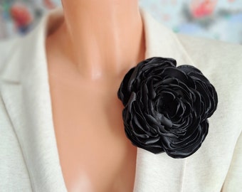 Broche de flor negra: elegante broche floral de rayón.