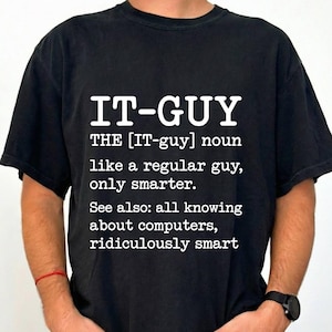 May include: A black short-sleeved t-shirt featuring white text that reads: IT-GUY THE [IT-guy] noun like a regular guy, only smarter. See also: all knowing about computers, ridiculously smart. The shirt has a crew neckline and a standard fit.