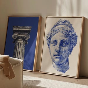 May include: Two framed rectangular wall art pieces. The left piece features a black and white illustration of a classical column against a solid blue background. The right piece displays a blue ink sketch of a classical bust on a cream background.