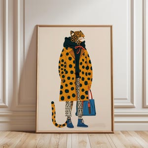 Może przedstawiać: Oprawiony wydruk artystyczny przedstawiający stylizowaną ilustrację osoby w cętki w żółtym płaszczu w czarne kropki, czarnej bluzie z kapturem i wzorzystych spodniach. Gepard trzyma niebieską torbę i nosi niebieskie buty. Tematyka modowa.