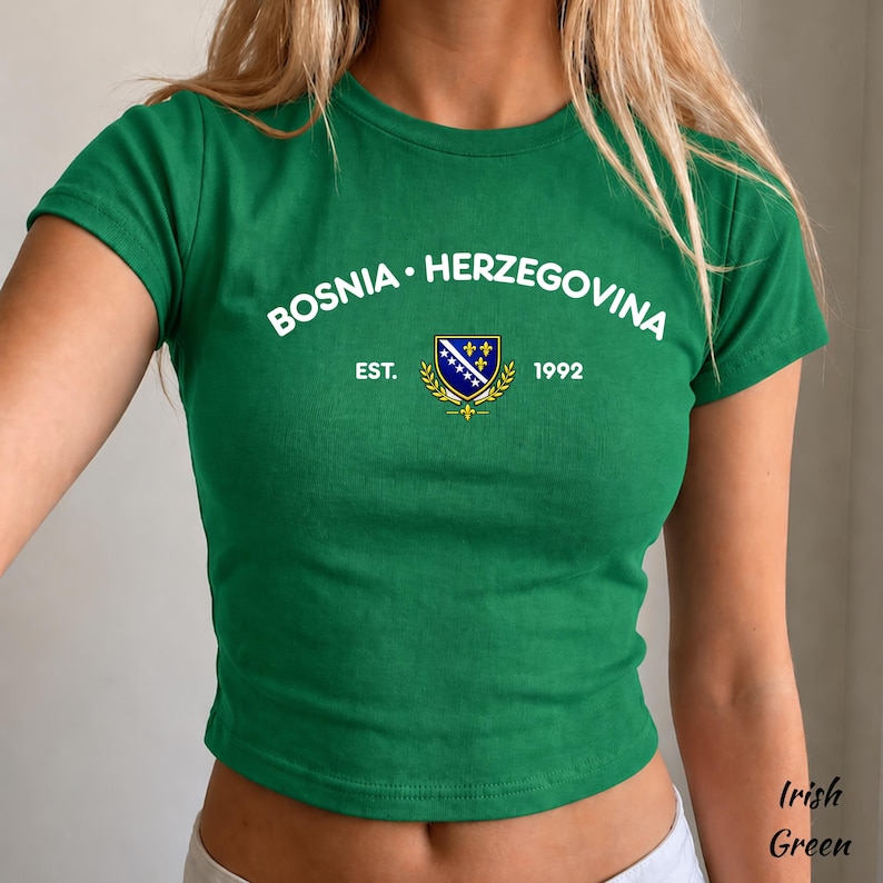 Pu&ograve; includere: Un top corto verde con la scritta bianca "BOSNIA &bull; HERZEGOVINA", uno stemma e l'anno "1992". La maglietta &egrave; di colore verde irlandese unito.