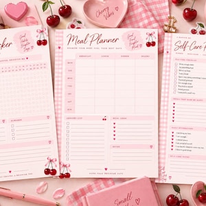 May include: Three pink and white gingham-themed paper planners titled Habit Tracker, Meal Planner, and Self-Care Planner. Each sheet features cherry illustrations, checkboxes, and lined sections for daily organization, goal setting, and personal notes.