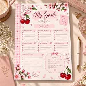 May include: A goal-setting planner sheet featuring a pink gingham border, cherry illustrations, and cherry blossom accents. The text includes My Goals, A Happier Me, Personal Goals, Health & Wellness, Career/Study, Financial Goals, Relationships, Lifestyle Goals, Steps to Get There, and I Will with checkboxes for daily affirmations.