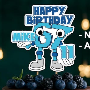 Peut inclure: Une décoration de gâteau personnalisée avec le texte HAPPY BIRTHDAY, le prénom MIKE et le chiffre 11 dans une police pixelisée bleue. Le design inclut un personnage de dessin animé aux grands yeux, membres bleus et chaussures grises.