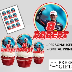 Puede incluir: Cupcakes rojos con glaseado blanco, cubiertos con imágenes circulares de un piloto de carreras. La imagen también incluye pegatinas y el texto "ROBERT" y "PERSONALIZADO - IMPRESIÓN DIGITAL".