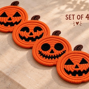 Puede incluir: Un conjunto de cuatro posavasos redondos de ganchillo naranja con forma de calabazas, cada uno con un tallo marrón oscuro y una cara negra cosida única. El texto SET OF 4 está impreso en la esquina superior derecha.