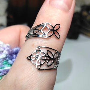 Polished silver‑toned stainless steel open‑design ring featuring the Witch’s Knot symbol. Adjustable band, lightweight and durable. Sacred protection and balance talisman.