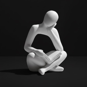 Op de afbeelding: Een witte, minimalistische sculptuur van een zittend persoon die een boek leest. Het hoofd van de figuur rust op zijn hand, wat duidt op contemplatie. De sculptuur staat tegen een donkere achtergrond, die de vorm benadrukt.
