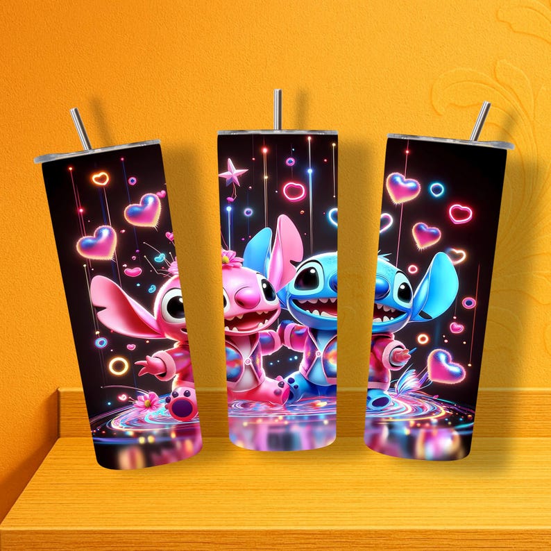 May include: Three stainless steel tumblers with straws, featuring a colorful design of cartoon characters. The tumblers have a black background with pink and blue hearts, stars, and neon accents. The characters are pink and blue.