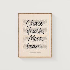 May include: A framed print featuring a vintage book page with the words "Chase death Moon beam" in a handwritten style. The text is in black, and the frame is a light brown color. The print is a literary-themed artwork.