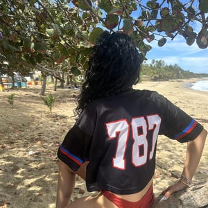 K&ouml;nnte beinhalten: Eine wei&szlig;e Keramik-Tasse mit schwarzem Henkel und dem Text "But First, Coffee" in handschriftlichem Stil. Die Tasse steht auf einer wei&szlig;en Oberfl&auml;che. Die Tasse ist etwa 10 cm hoch.