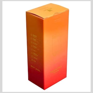 May include: A tall, rectangular cardboard product box with a gradient color scheme transitioning from orange at the top to red at the bottom. The box features the Stanley brand logo and the text Quencher H2.0 Tumbler printed in a metallic gold finish.