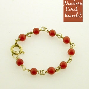 Puede incluir: Un brazalete de coral rojo con cierre de oro. El brazalete est&aacute; hecho con peque&ntilde;as cuentas de coral redondas y alambre de oro.