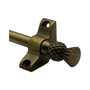 May include: Antique brass curtain rod hardware featuring a decorative pineapple finial. The hardware includes a bracket with two mounting holes and a rod. The pineapple finial adds a touch of elegance.