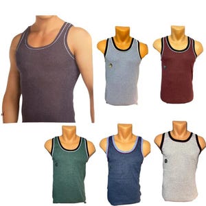 Könnte beinhalten: Sammlung von sechs Tanktops in verschiedenen Farben, darunter Grau, Burgunderrot und Blau. Die Tanktops haben kontrastierende Verzierungen am Halsausschnitt und an den Armausschnitten. Ein Tanktop wird von einer Person getragen, die anderen sind auf Schaufensterpuppen ausgestellt.