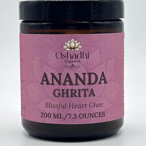 May include: A brown jar of Ananda Ghrita ghee with a black lid and a pink label. The label reads "Oshadhi Organics" and "ANANDA GHRITA Blissful Heart Ghee 200 ml/7.3 OUNCES". The jar is filled with a golden substance.