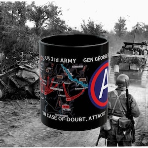 May include: A black ceramic mug featuring a graphic of the US 3rd Army map, the text "US 3rd ARMY", "GEN GEORGE S. PATTON", and "IN CASE OF DOUBT, ATTACK!", along with the 3rd Army insignia, a blue circle with a red border and a white letter A.