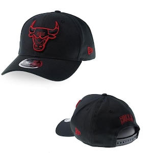 May include: A black baseball cap featuring an embroidered red Chicago Bulls logo on the front, a New Era logo on the side, and the word Bulls in red embroidery on the back. The cap includes a 9FIFTY sticker on the brim and an adjustable snapback.