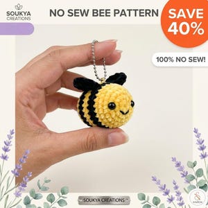 May include: A crocheted bee keyring in yellow and black, with a smiling face and black wings. The keyring is attached to a silver chain. The image includes the text "NO SEW BEE PATTERN" and "SAVE 40%."