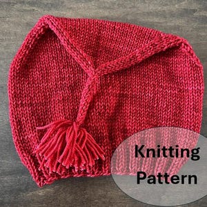 Könnte beinhalten: Eine gestrickte rote Mütze mit Quaste. Die Mütze hat eine spitze Oberseite und eine geflochtene Kordel, die zur Quaste führt. Der Text "Knitting Pattern" befindet sich in einem transparenten Oval rechts unten.