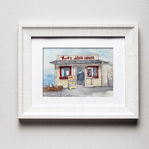 Op de afbeelding: Een aquarel van een klein geel gebouw met een rode luifel waarop "Red's Java House" staat. Het gebouw heeft een deur en twee ramen. Er zijn twee meeuwen voor het gebouw.