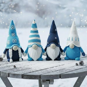 Könnte beinhalten: Vier handgefertigte Wichtel mit blau-weißen Strickmützen und -körpern. Jeder Wichtel hat einen weißen Bart und hält die Hände der anderen. Die Wichtel sitzen auf einem Holztisch mit verschneitem Hintergrund.
