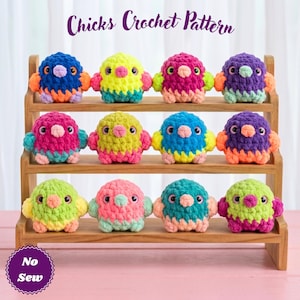 Puede incluir: Una estantería de madera exhibe doce pollitos de ganchillo coloridos. Cada pollito tiene un cuerpo redondo, pequeñas alas y un pico. Los pollitos son de varios colores, incluyendo azul, amarillo, rosa y morado. El texto "Chicks Crochet Pattern" es visible.