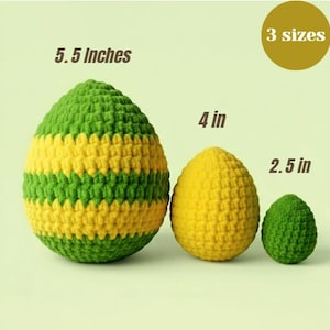 Könnte beinhalten: Drei gehäkelte Eier in verschiedenen Größen. Das größte ist grün und gelb, misst 14 cm. Das mittlere Ei ist gelb und 10 cm groß. Das kleinste Ei ist grün und 6,4 cm groß. Das Bild enthält den Text "3 Größen".