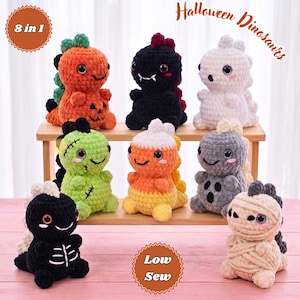 Può includere: Otto dinosauri di peluche all'uncinetto con temi di Halloween, inclusi disegni di zucca, fantasma, mummia e scheletro. I giocattoli presentano grandi occhi in plastica e texture in filato morbido, disposti su uno scaffale con il testo 8 in 1 e Low Sew.