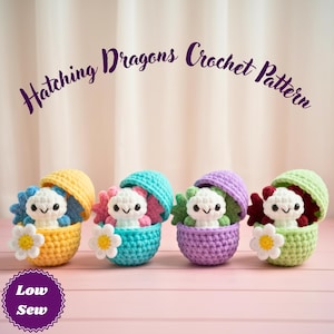May include: Four crocheted dragon toys in colorful eggshells. Each dragon has a white face and colorful accents, with a daisy flower attached. The eggshells are yellow, turquoise, purple, and green. The text "Hatching Dragons Crochet Pattern" is arched above the toys.