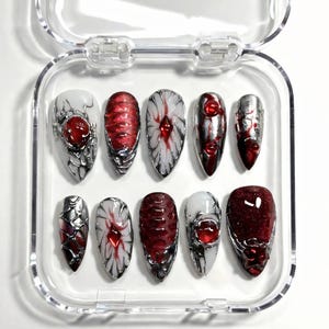 Uñas postizas de vampiro gótico: gemas rojas con gotas de sangre y escamas de dragón.