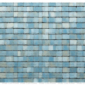 May include: A close-up shot of a textured surface composed of small, square, blue-gray tiles. The tiles are arranged in a grid pattern, creating a repeating design. The overall effect is a cool, neutral color palette.