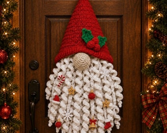 Può includere: Una decorazione da parete a forma di gnomo all'uncinetto con un alto cappello rosso decorato con foglie di agrifoglio verdi e bacche rosse. Lo gnomo ha un naso beige e una lunga barba bianca riccia decorata con piccoli ornamenti.