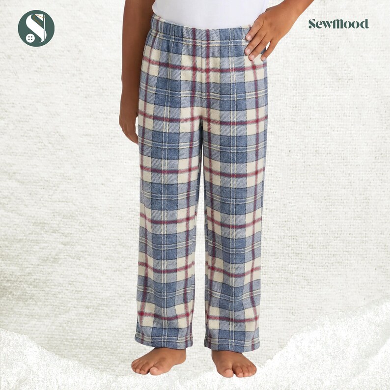May include: Blue, cream, and burgundy plaid pajama pants. The pants have an elastic waistband and a relaxed fit. The Sewmood logo is visible in the upper right corner. These pants are suitable for sleepwear or lounging.
