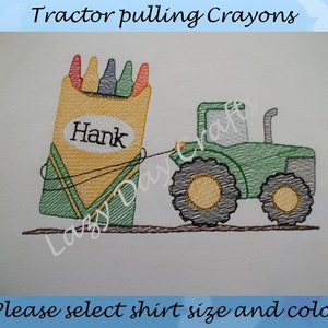 May include: A green tractor pulls a box of crayons with the name "Hank" on it. The crayons are red, orange, yellow, green, and blue.
