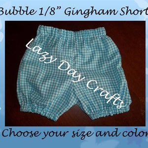 May include: Blue and white gingham bubble shorts with a white elastic waistband. The shorts are made by Lazy Day Crafts.